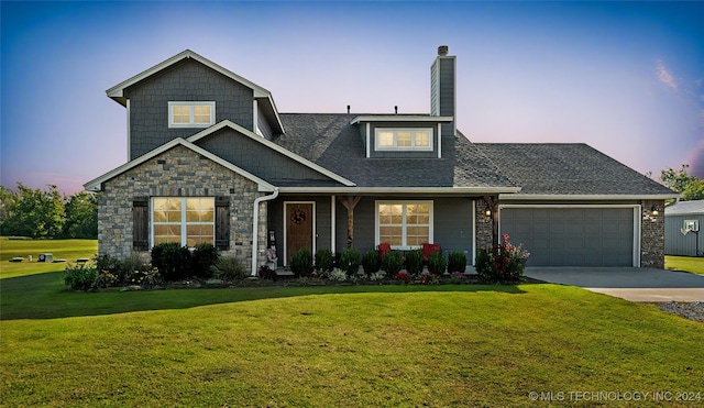 view of front of property with a yard and a garage