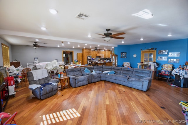 living room featuring ceiling fan and light hardwood / wood-style floors