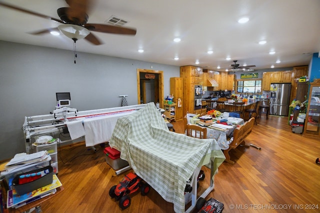 living room featuring ceiling fan and light hardwood / wood-style flooring