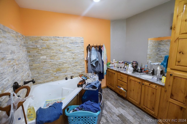 bathroom with a tub to relax in, vanity, and hardwood / wood-style floors