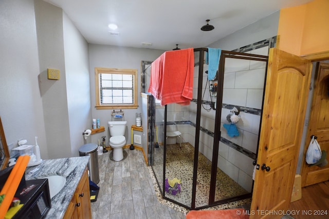 bathroom featuring an enclosed shower, toilet, hardwood / wood-style flooring, and vanity