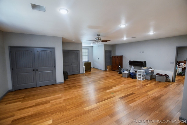 living room featuring light wood-type flooring and ceiling fan