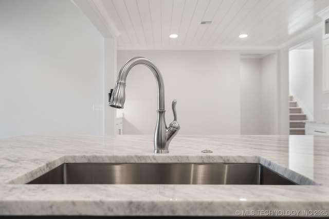 interior details featuring wooden ceiling, light stone counters, a sink, and recessed lighting