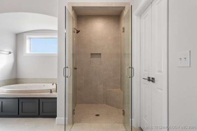 full bathroom featuring a stall shower and a bath