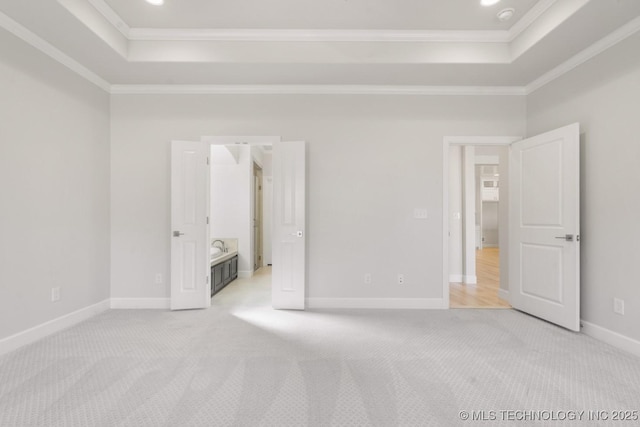 unfurnished bedroom featuring a raised ceiling, light carpet, and crown molding