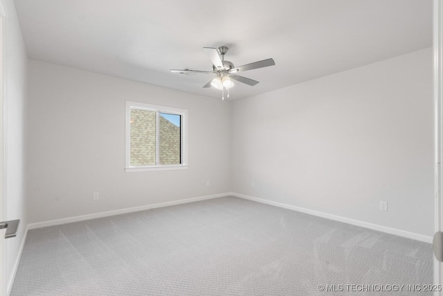 carpeted empty room with a ceiling fan and baseboards