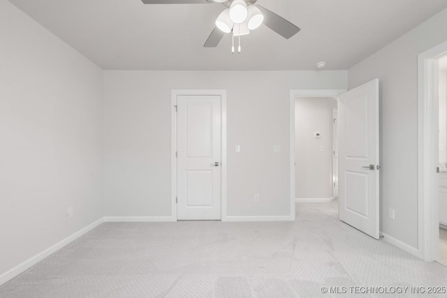 unfurnished bedroom with a ceiling fan, baseboards, connected bathroom, and light colored carpet