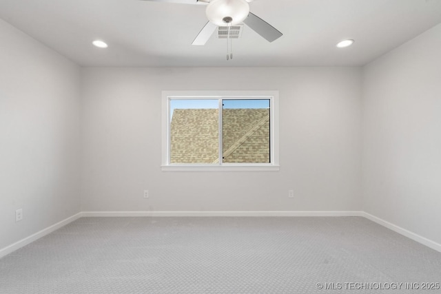 empty room with carpet, visible vents, and baseboards