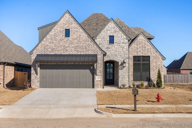 french country style house featuring a garage, fence, concrete driveway, and brick siding