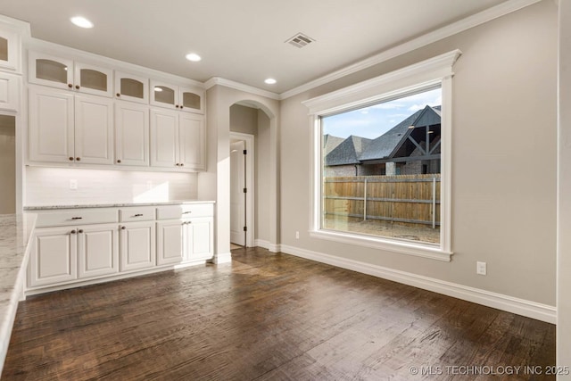 interior space featuring white cabinetry, dark wood-type flooring, and light stone counters