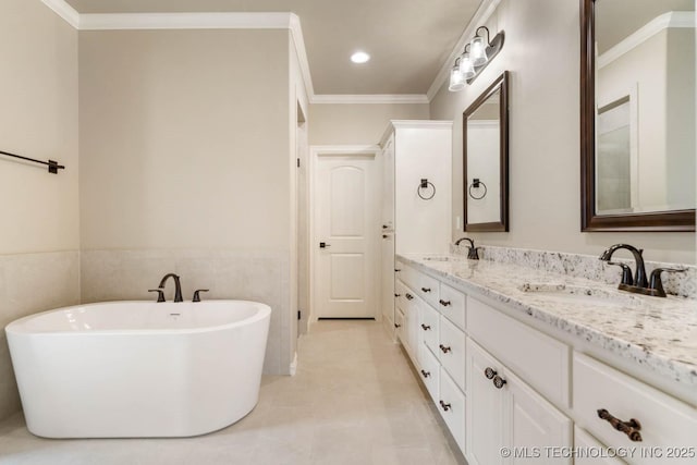 bathroom featuring a bathtub, vanity, crown molding, tile walls, and tile patterned flooring