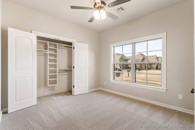 unfurnished bedroom with ceiling fan, a closet, and light carpet