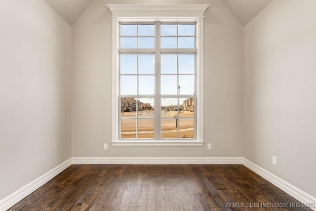 unfurnished room with dark hardwood / wood-style floors and vaulted ceiling