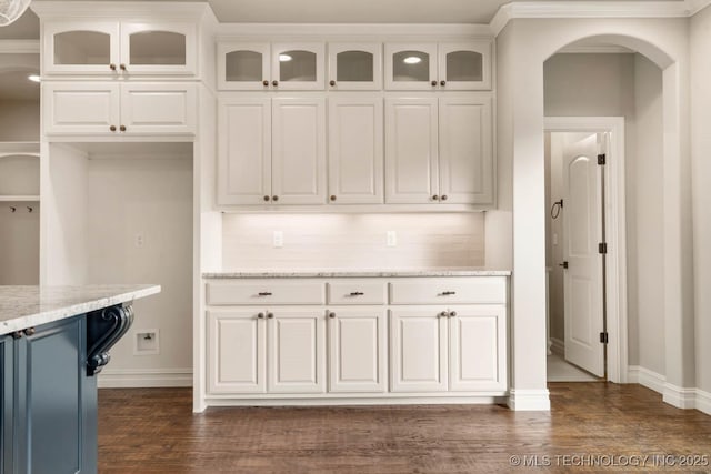 kitchen with decorative backsplash, dark hardwood / wood-style floors, light stone countertops, and white cabinetry