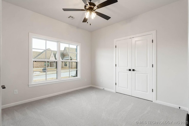 unfurnished bedroom with light carpet, a closet, and ceiling fan