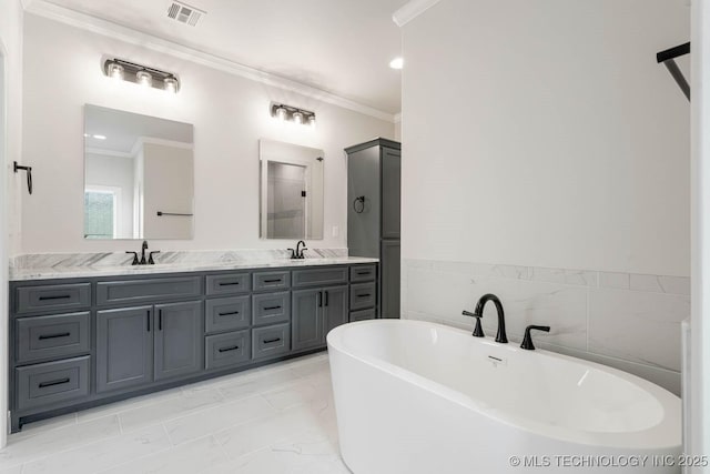 bathroom featuring a washtub, vanity, and crown molding