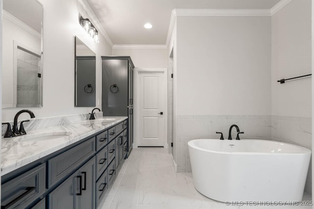 bathroom featuring a bath, vanity, tile walls, and crown molding