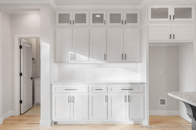 kitchen featuring light stone countertops, light hardwood / wood-style flooring, and white cabinetry