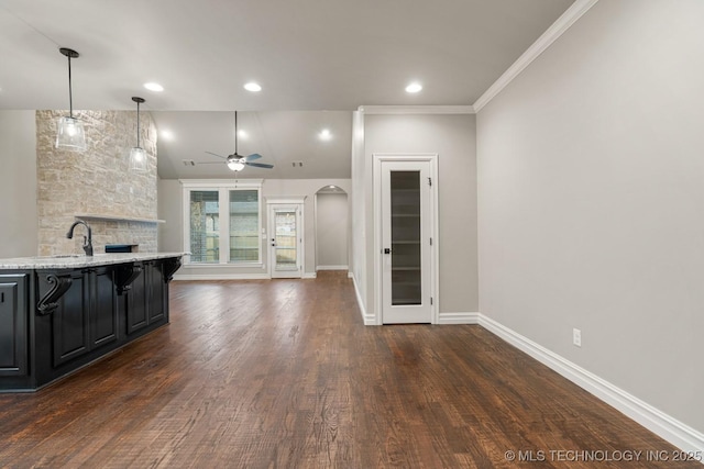 14504 E 80th St, Owasso, OK 74055 - kitchen with arched walkways, dark wood finished floors, open floor plan, dark cabinetry, and ceiling fan