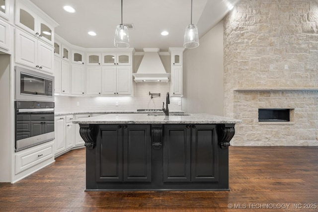 14504 E 80th St, Owasso, OK 74055 - kitchen featuring premium range hood, appliances with stainless steel finishes, light stone countertops, and white cabinetry