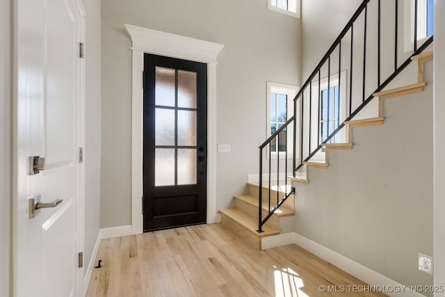 entrance foyer featuring stairs, wood finished floors, and baseboards