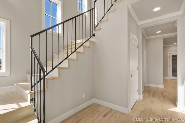 stairs with ornamental molding, recessed lighting, baseboards, and wood finished floors