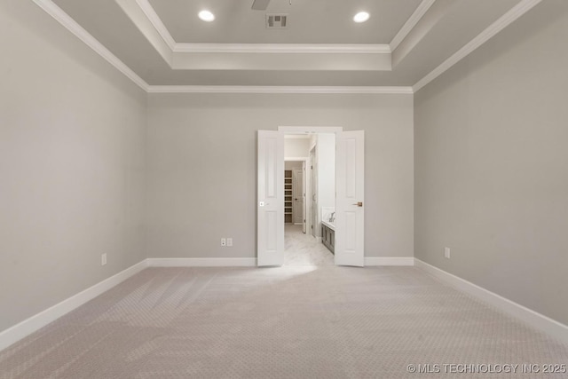 carpeted spare room featuring visible vents, a raised ceiling, and ornamental molding