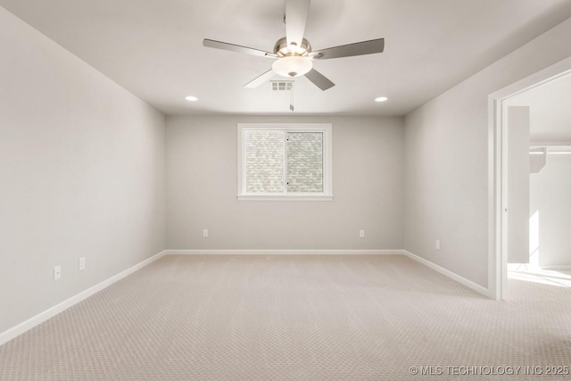 spare room featuring light colored carpet, visible vents, ceiling fan, and baseboards