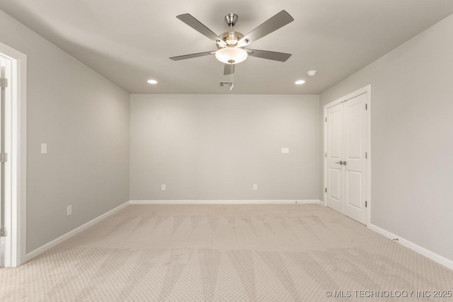 spare room with recessed lighting, light carpet, ceiling fan, and baseboards