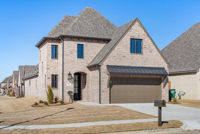 french provincial home with driveway, a shingled roof, and brick siding