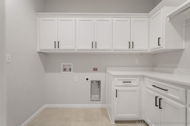 clothes washing area with baseboards, washer hookup, cabinet space, and electric dryer hookup