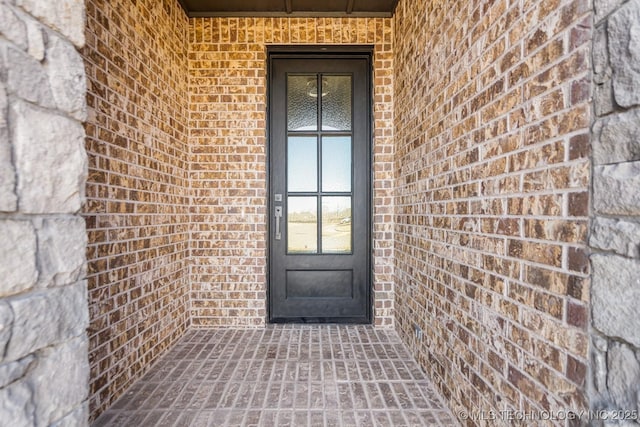 doorway to property featuring brick siding