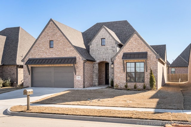 view of front of house featuring metal roof, brick siding, driveway, stone siding, and a standing seam roof