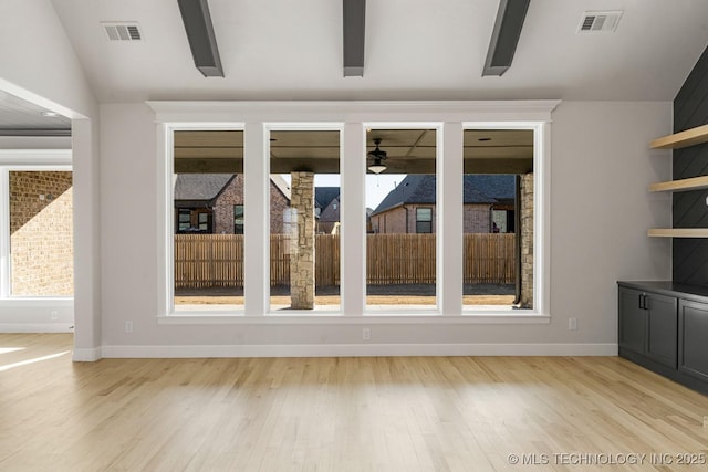 interior space with ceiling fan, lofted ceiling, and visible vents