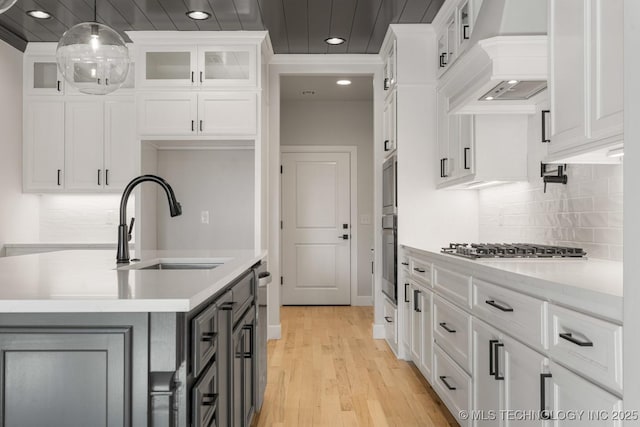 kitchen featuring light countertops, custom exhaust hood, and white cabinets