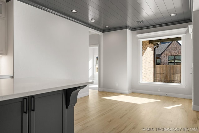 interior space featuring visible vents, baseboards, wood ceiling, crown molding, and light wood-style floors