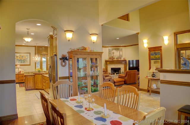 tiled dining room with ornamental molding and a notable chandelier