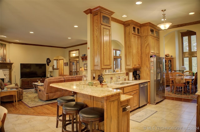 kitchen featuring light stone counters, stainless steel appliances, light hardwood / wood-style floors, sink, and kitchen peninsula