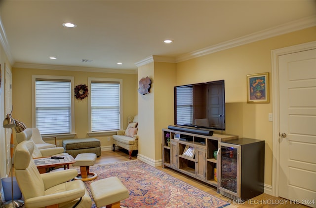 living room with crown molding and light hardwood / wood-style flooring