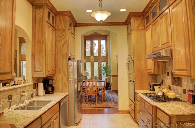 kitchen with light hardwood / wood-style flooring, decorative light fixtures, stainless steel appliances, sink, and exhaust hood