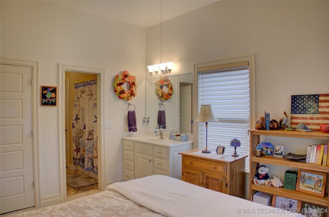 bedroom featuring ensuite bathroom and a chandelier