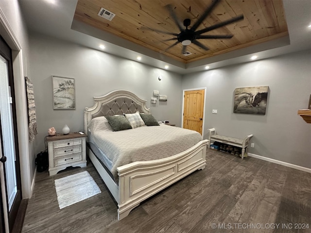 bedroom with a tray ceiling, dark wood-type flooring, ceiling fan, and wooden ceiling