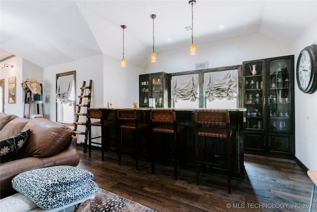 bar with pendant lighting, dark hardwood / wood-style floors, and vaulted ceiling