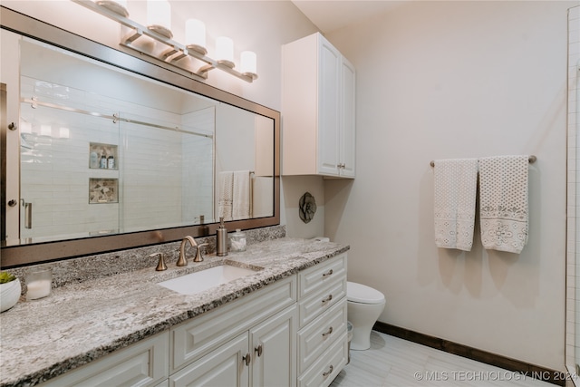 bathroom featuring vanity, toilet, and a shower with shower door