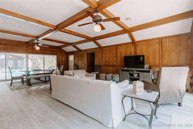 living room with vaulted ceiling with beams, wood walls, ceiling fan, and light hardwood / wood-style flooring