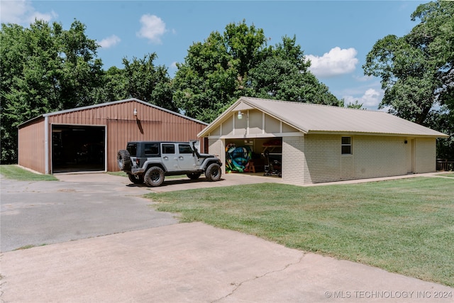 view of front of house with an outdoor structure, a garage, and a front lawn