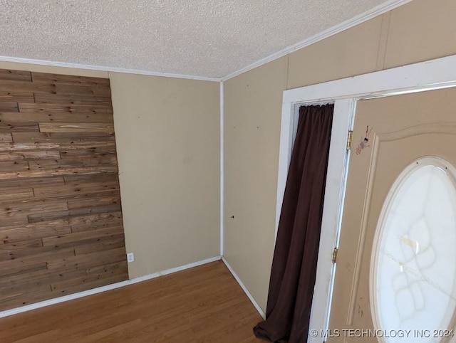 interior space with ornamental molding, a textured ceiling, and hardwood / wood-style floors