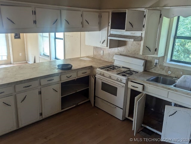 kitchen with white range with gas stovetop, light wood-type flooring, white cabinetry, and tasteful backsplash