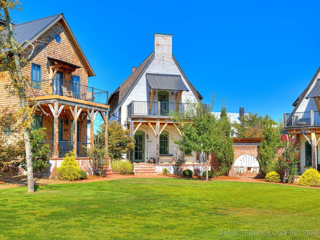 view of front of property with a balcony, a front yard, and a porch