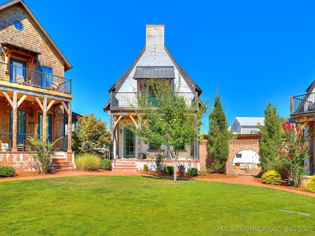 exterior space with a yard, covered porch, and a balcony